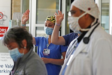 Health care workers wave to a departing patient, who recovered from being stricken with COVID-19, outside the Southern New Hampshire Medical Center in Nashua, N.H., Wednesday, May 27, 2020. (Photo | AP)