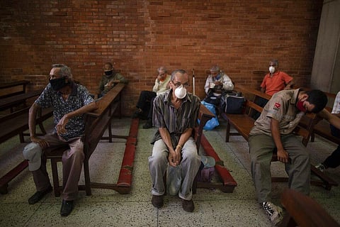 People, wearing protective face masks as a precaution against the spread of the new coronavirus, wait to receive a free meal at a church in The Cemetery neighborhood of Caracas, Venezuela, Friday, May 22, 2020. (Photo | AP)