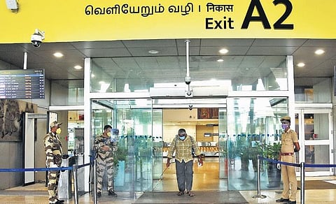 A man sprays disinfectant near the exit terminal of Chennai Airport | ashwin prasath