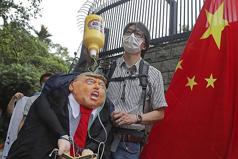 Pro-China supporters hold the effigy of U.S. President Donald Trump and Chinese national flag outside the U.S. Consulate during a protest in Hong Kong, Saturday, May 30, 2020. (Photo | AP)