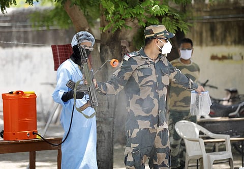 Border Security Force personnel disinfect themselves on their return after patrolling during ongoing COVID-19 lockdown in Ahmedabad Friday May 29 2020. (Photo | PTI)