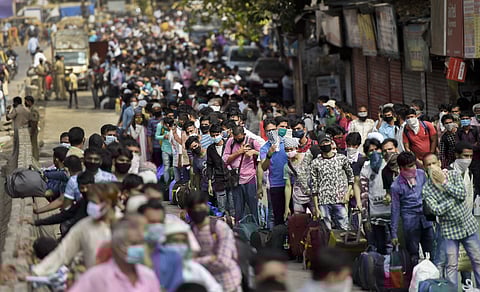 Migrants gather outside Dharavi slum to board buses for a railway station for their onward journey by special train to reach their native places during ongoing COVID-19 lockdown in Mumbai Sunday May 24 2020. (Photo | PTI)