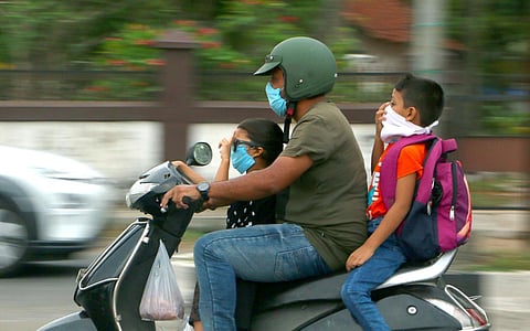 A family riding through the city in Kozhikode with masks on. (Photo | TP Sooraj, EPS)