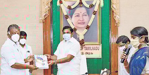 Chief Minister Edappadi K Palaniswami handing over the first copy of ‘Comprehensive Guidelines Covid-19’ book, brought out by Tamil Nadu Health and Family Welfare Department, to Deputy Chief Minister O Panneerselvam at the Secretariat on Saturday. (Photo|
