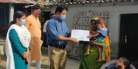 DM katihar giving cheque of assistance and document of residential land lease. (Photo | Facebook)
