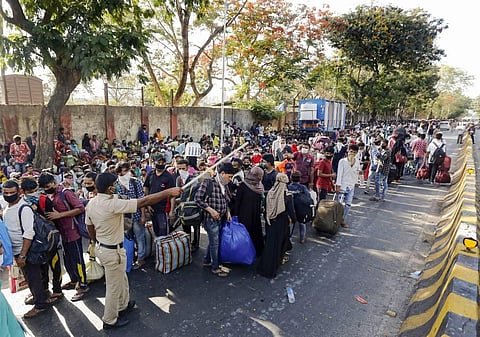 Migrants wair outside Chhatrapati Shivaji Maharaj Terminus to catch the special train to reach their native places during the ongoing COVID-19 lockdown in Mumbai. (Photo | PTI)