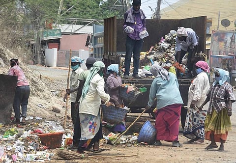 Yanamalakuduru panchayat sanitation staff clear garbage without wearing masks and gloves at Yanamalakuduru in Vijayawada on Saturday. (Photo | P Ravindra Babu, EPS)