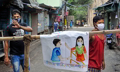 Locals stand near a temporary barricade to restrict movement of outsiders during a nationwide lockdown in the wake of coronavirus pandemic in Kolkata Sunday May 3 2020. (Photo | PTI)