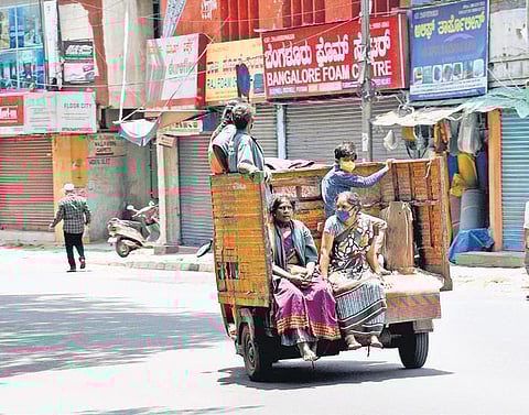 Pourakarmikas return home after a hard day at work in Bengaluru, where lockdown restrictions were eased, on Monday | Nagaraja Gadekal