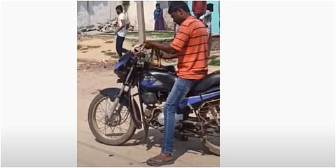 The youth with the dead snake in his hand (YouTube screen grab)