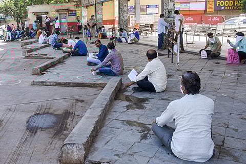Stranded people practice social distancing as they wait in queues to board buses for their native places amid COVID-19 lockdown in Surat Thursday May 7 2020. (Photo | PTI)