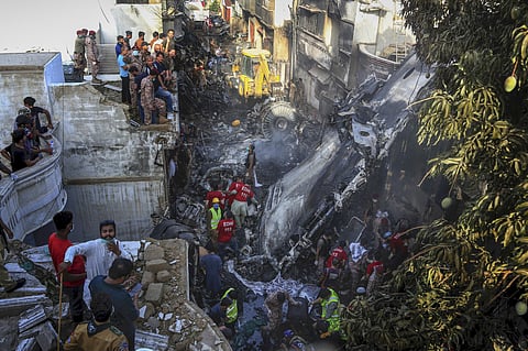 Volunteers look for survivors of a plane that crashed in a residential area of Karachi, Pakistan. (File Photo | AP)