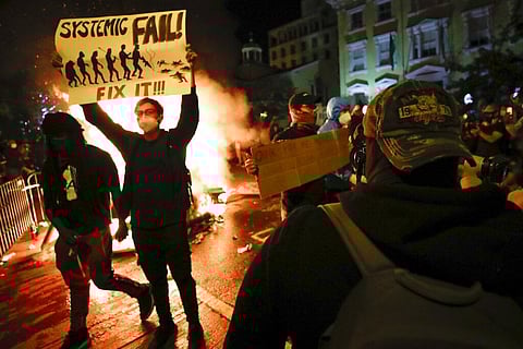 Demonstrators protest the death of George Floyd, Sunday, May 31, 2020, near the White House in Washington. Floyd died after being restrained by Minneapolis police officers. (Photo | AP)