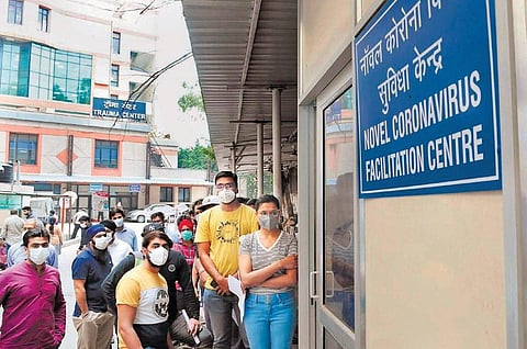 People wearing masks stand outside RML Hospital in New Delhi (Photo | EPS)