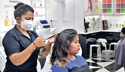 A staffer at a parlour attends to a customer while taking precautions in Bengaluru. (Photo | Meghana Sastry/EPS)
