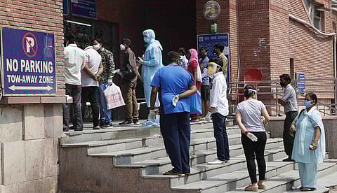 People stand outside of the LNJP hospital during the nationwide lockdown in Delhi on Sunday. (Photo | Anil Shakya/EPS)