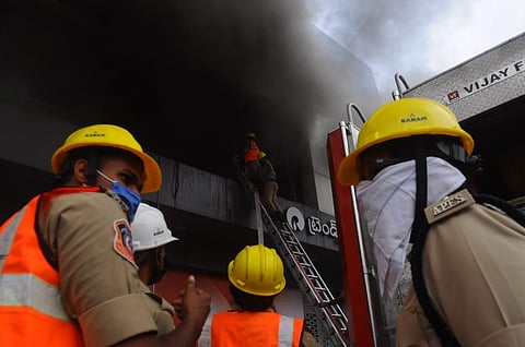 A firefighter was injured during his fire dousing operations at Reliance Trends in Vijayawada. (Photo | Prasant Madugula, EPS)