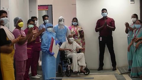 Hospital staff clap and cheer the 97-year-old man who recovered from coronavirus. (Photo | Express)