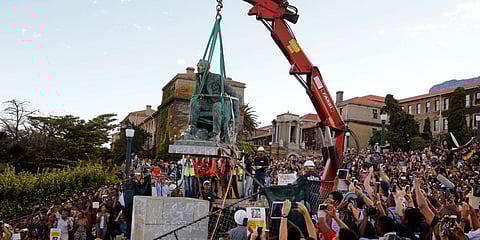 In this April 9, 2015, file photo, cheering students surround a statue of British colonialist Cecil Rhodes, as it is removed from the campus at the Cape Town University, Cape Town, South Africa. (File Photo | AP)