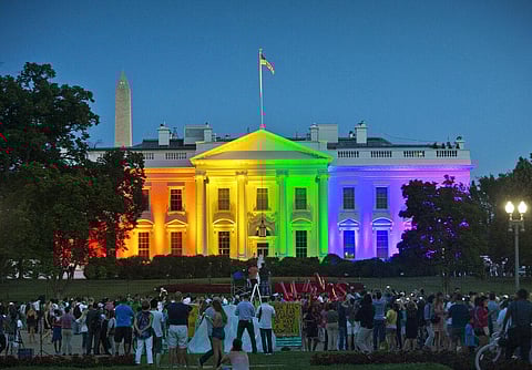 In this Friday, June 26, 2015 file photo, people gather in Lafayette Park to see the White House illuminated with rainbow colors in commemoration of the Supreme Court's ruling to legalize same-sex marriage in Washington. The Trump administration Friday, J