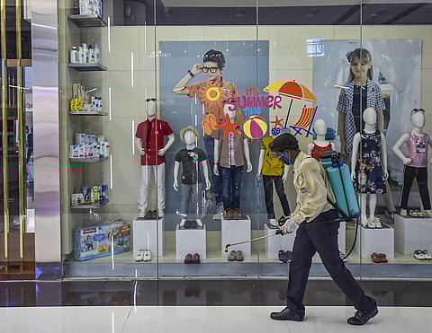 A worker sprays disinfectant inside a shopping mall in Kolkata. (Photo | PTI)