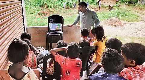 A volunteer handling a digital session for students at Uriyampetti tribal colony in Kuttampuzha forest area