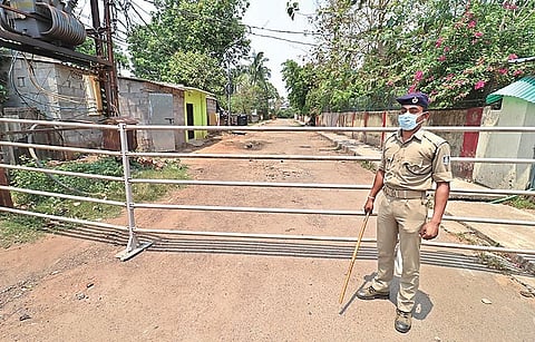 A policeman guards a lane during weekend shutdown in Bhubaneswar I Express