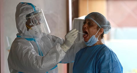 A medic collects a sample of a woman for COVID-19 testing during the ongoing nationwide lockdown in New Delhi. (Photo | Shekhar Yadav, EPS)