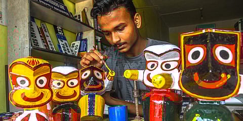 An artist busy colouring idols of Trinity at his shop in Bhubaneswar. (Photo| EPS)