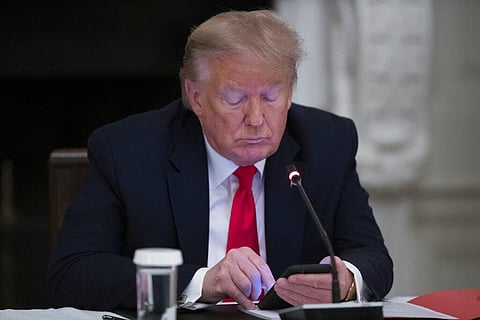 US President Donald Trump looks at his phone during a roundtable with governors on the reopening of America's small businesses, in the State Dining Room of the White House, Thursday, June 18, 2020, in Washington. (Photo | AP)