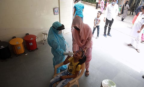 A health technician takes sample from a girl for COVID-19 testing via Rapid Antigen Kits in New Delhi on Friday. (Photo | Shekhra Yadav/EPS)
