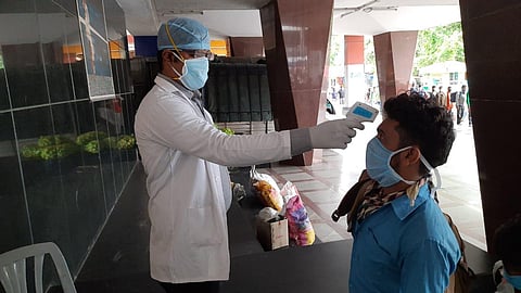 Passengers on way to board the Shramik Special to Gorakhpur from KSR Bengaluru City being thermal tested at the station. (Photo | EPS)