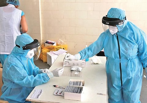 Health workers store a swab sample at a testing center in New Delhi | Shekhar Yadav