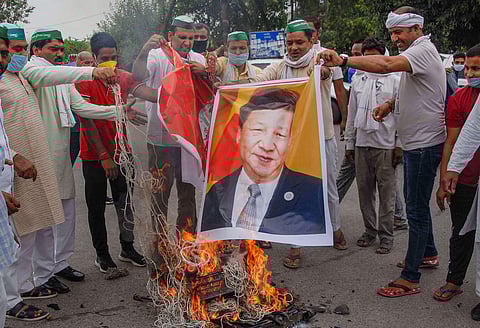 Workers of Bhartiya Kisan Union Bhanu burn a photo of Chinese President Xi Jinping during a protest against the killing of 20 Indian Army soldiers in a violent face-off with Chinese troops at Ladakh's Galwan Valley in Noida Saturday June 20 2020. (Photo |