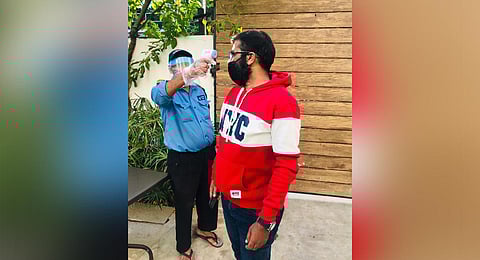A security staff in an eatery takes thermal screening of a customer in Hyderabad. (Photo| EPS)