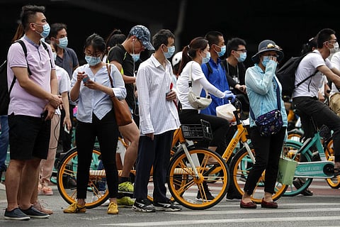 People wearing protective face masks to help curb the spread of the new coronavirus wait to cross a street in Beijing, Monday, June 22, 2020. (Photo | AP)