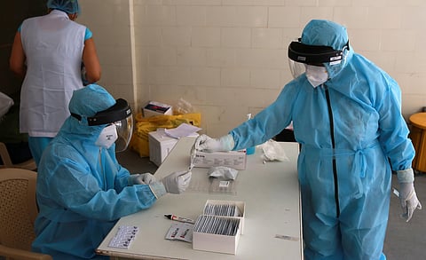 Health workers store a swab sample collected at a Covid-19 testing center in New Delhi on Friday. (Photo | Shekhar Yadav/EPS)