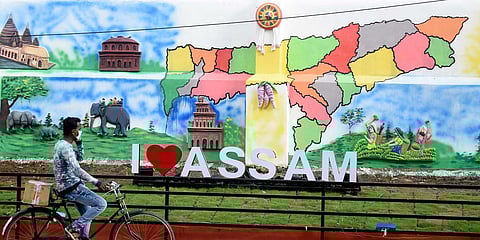 A man rides his cycle past a mural during the ongoing COVID-19 lockdown in Guwahati. (Photo| ANI)