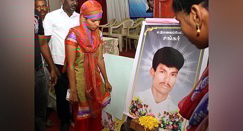 Kowsalya stands before a photo of her husband Shankar who was killed in broad daylight in Udamalapet. (Photo | Express)