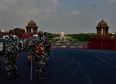 Security personnel walk at Raisina Hills in the backdrop of clouds looming in the sky in New Delhi Tuesday June 23 2020. (Photo | PTI)