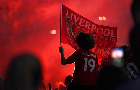 Liverpool supporters celebrate as they gather outside of Anfield Stadium in Liverpool. (Photo | AP)