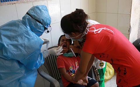 A health official collects a swab sample from a child during the Government conduct rapid antigen COVID-19 tests at Lado sarai in New Delhi on Friday. (Photo | Shekhar Yadav/EPS)