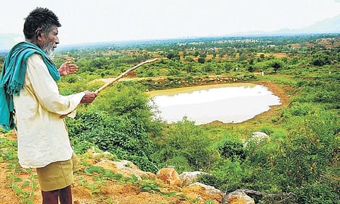 Kaamegowda stands near one of the ponds he built. The octogenarian has built 16 ponds on the barren Kundinibetta hill in Mandya district | Pandarinath B