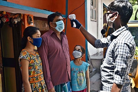 Healthcare workers check temperature of a family in Karunanidhi Nagar area of Washermenpet, Chennai. (Photo | P Jawahar, EPS)