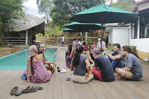 In this April, 2020, photo, stranded tourists rest at the Cafe Chill in Ella, a tourist hot spot about 200 kilometers (120 miles) east of the capital Colombo, Sri Lanka. When flights were canceled and airports shut down, cafe owner Darshana Ratnayake deci