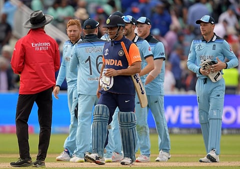 India's Mahendra Singh Dhoni (C) walks off the field after defeat in the 2019 Cricket World Cup group stage match between England and India at Edgbaston in Birmingham. (Photo | AFP)