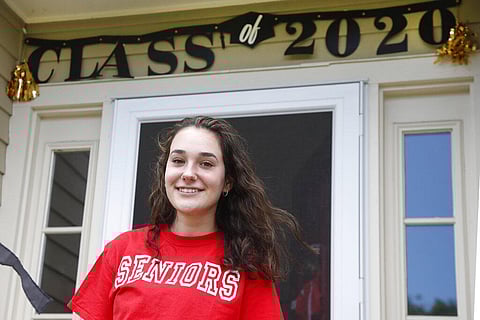 High school graduate Lizzie Quinlivan poses at her home in Hingham, Mass. Quinlivan has opted to attend closer-to-home Georgetown instead of colleges on the west coast which were on her original wish-list. (Photo | AP)