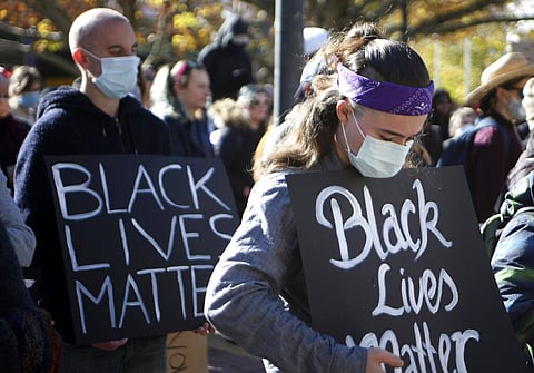 Demonstrators observe a minute's silence in Canberra, Australia, on Friday, June 5, 2020 in memory of deaths in custody including George Floyd, who died after being restrained by Minneapolis police officers on May 25. Thousands gathered in Australia's cap