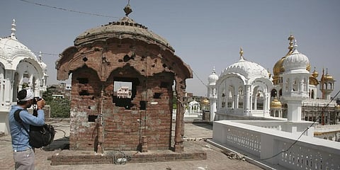 A photographer takes pictures of a damaged dome with bullet marks inside the complex of the Golden Temple. (File Photo | AP)