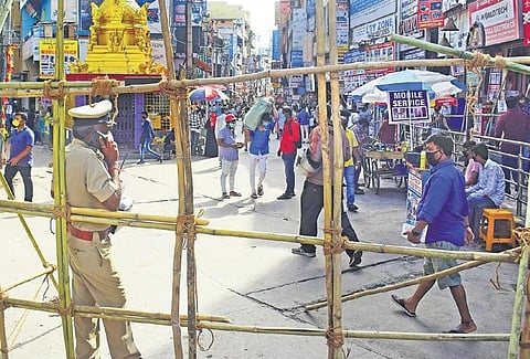 A police official monitors the situation on SP Road in Bengaluru on Saturday, which was declared a containment zone recently | Pandarinath B